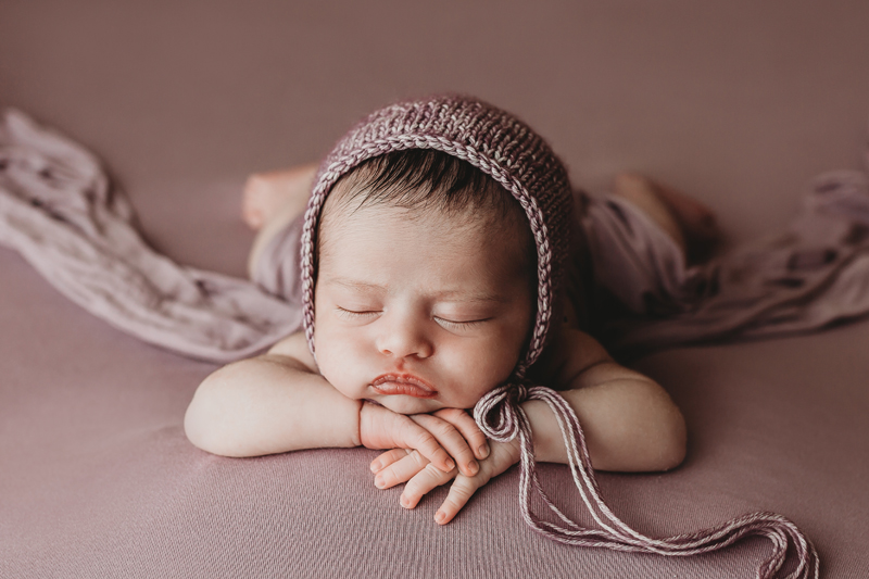 Moseley, Virginia newborn photographers, newborn baby girl asleep dusty purple backdrop with dusty purple knit bonnet