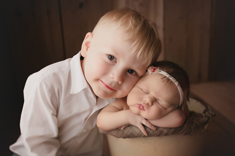 Moseley, virginia newborn photographer, newborn girl in a bucket pose with her big brother snuggling her cheek with his cheek