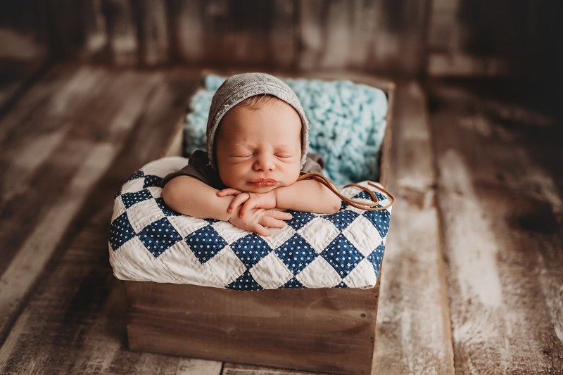 Richmond, Virginia newborn pics, newborn boy with chin on hands asleep in wood box on barn wood floor
