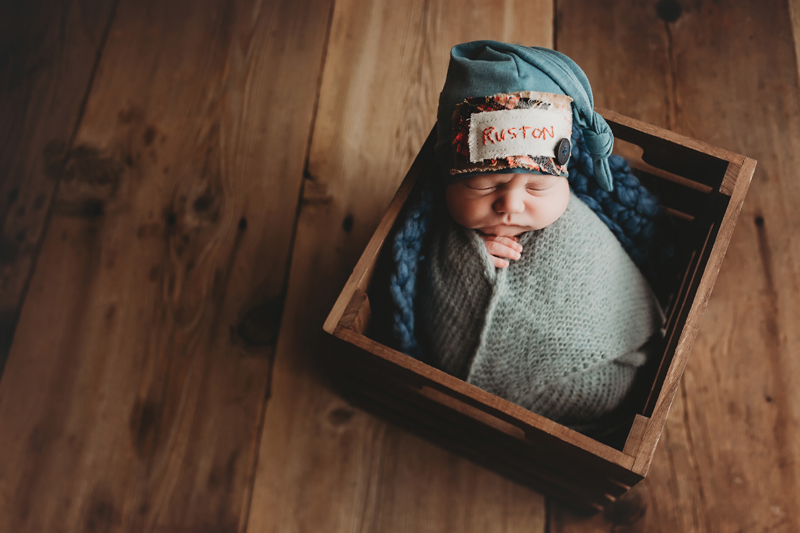 Midlothian, Virginia photographers, newborn baby boy with knit light blue wrap and dusty blue newborn sleepy cap in box