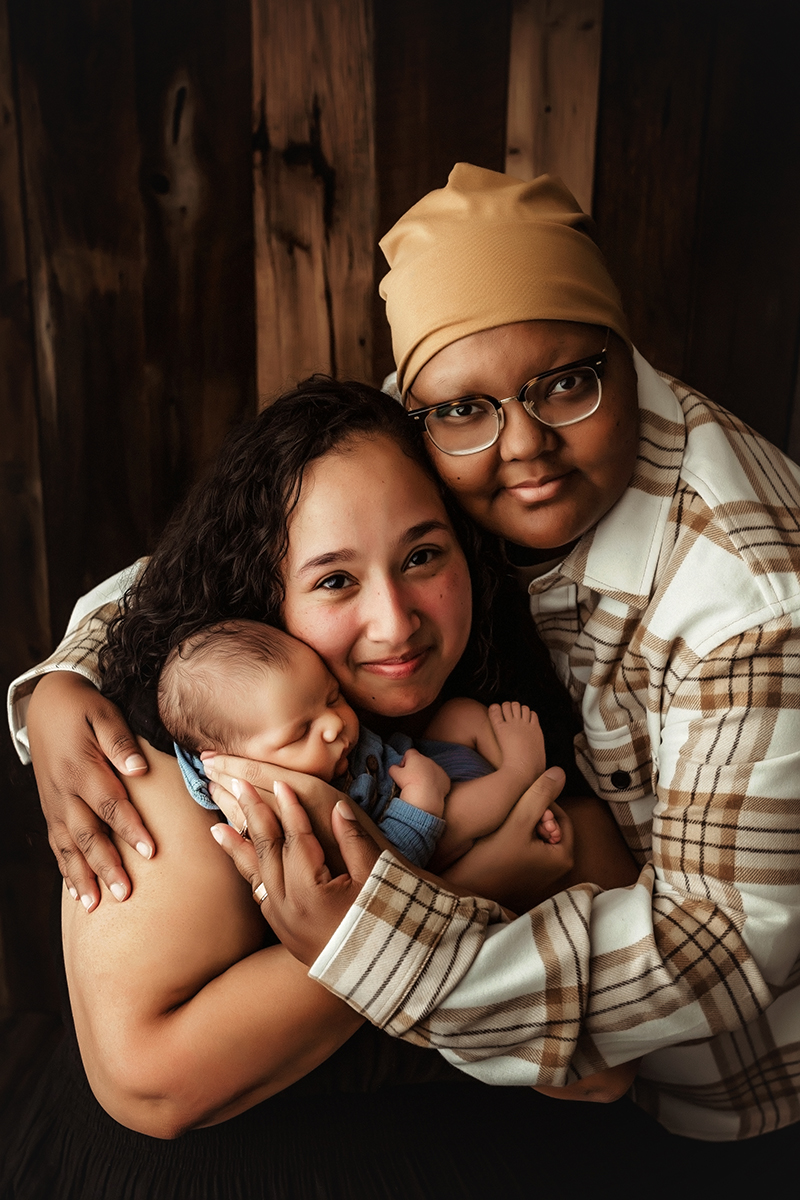 Williamsburg, Virginia newborn photographer female couple holding their newborn son looking at the camera