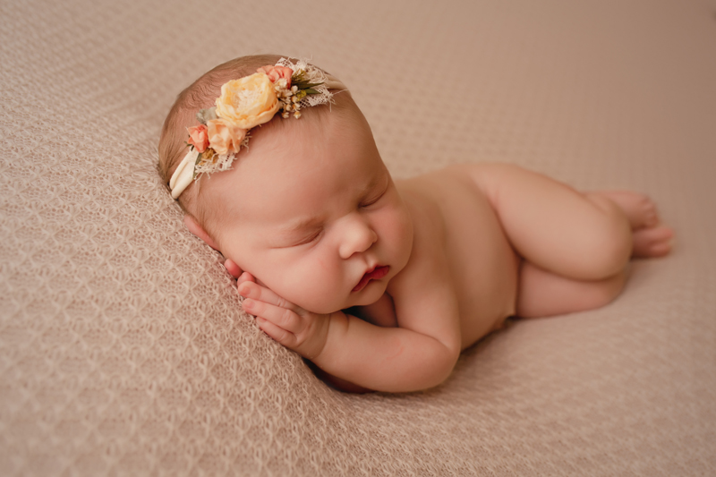 Lawton, Oklahoma newborn photographer, newborn baby girl sleeping on her side with a flower headband