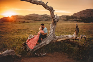 Midlothian photographer, Moseley photographer, Richmond newborn photographer, couple sitting on tree with mountains and sunset behind them,