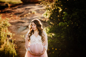 Lawton, Oklahoma maternity photographer, pregnant woman in lace and pink dress holding her bump