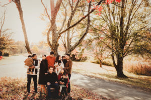 Charlottesville photographer, extended family looking at one another under tree holding babies and kids with grandparents