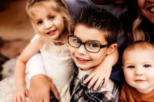 Moseley, Virginia photographer, three kiddos looking at camera in their parents arms