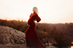 Lawton pregnant woman in red long fitted dress in Wichita Mountains Wildlife Refuge