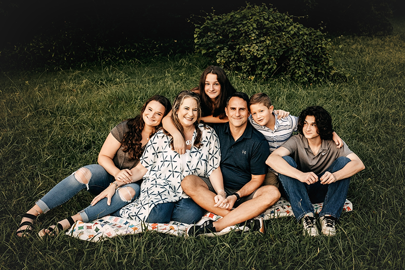 family photos now with your favorite Richmond photographer, family sitting on grass looking at camera and smiling