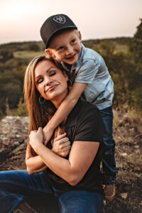 lawton Oklahoma photographer, mom with young son wearing a hat wrapping his arms around his mom