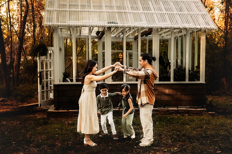 Richmond, Virginia photographer, family of four playing London Bridge in front of Midlothian greenhouse